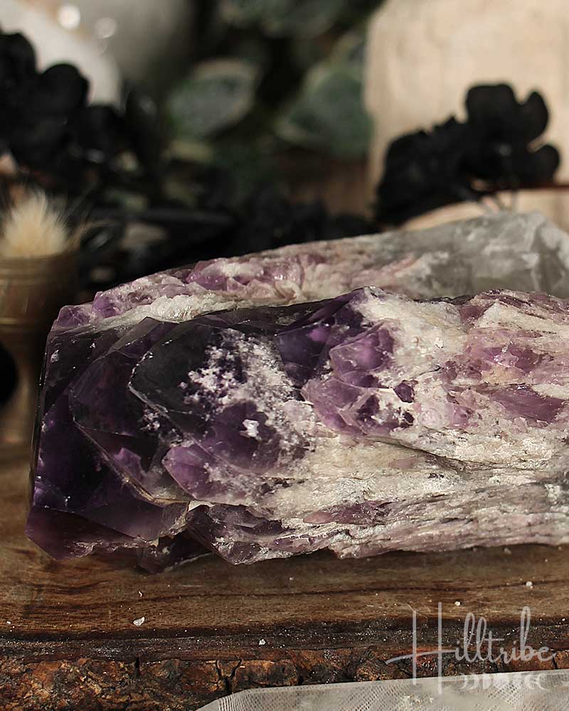 Amethyst crystal on a wooden surface with blurred background