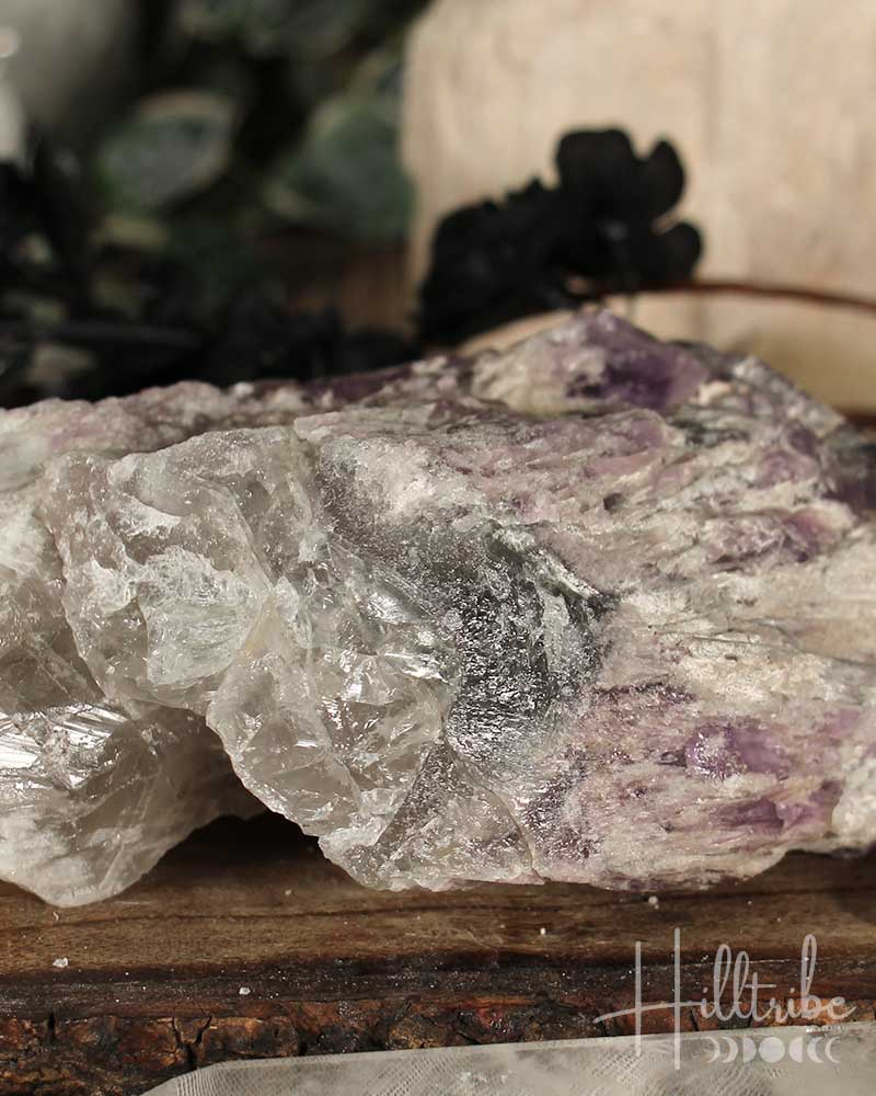 Close-up of a crystal rock with visible minerals on a wooden surface, blurred background