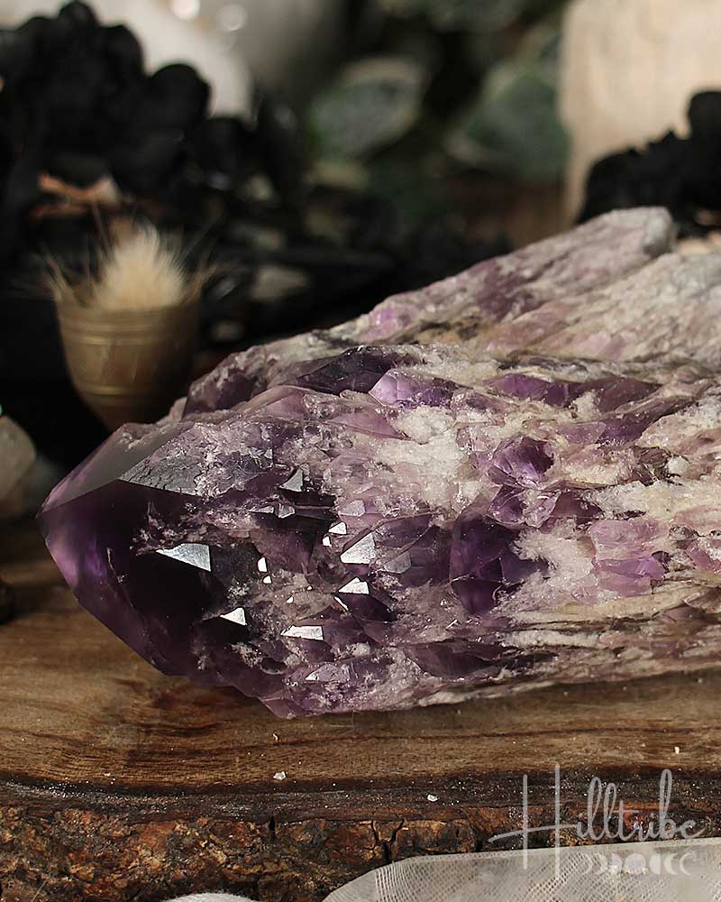 Close-up of a purple crystal on a wooden surface with blurred background