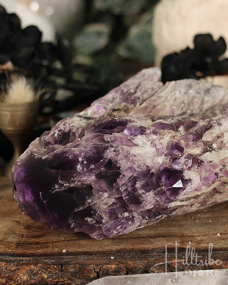Close-up of a purple crystal on a wooden surface with blurred background
