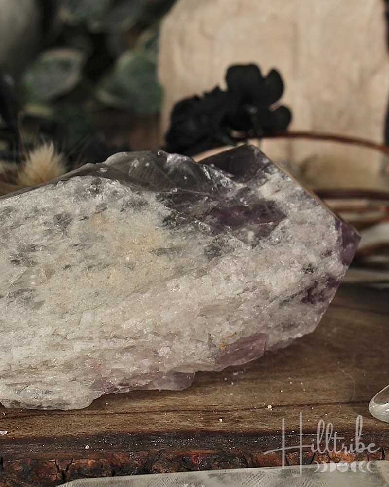 Amethyst crystal on a wooden surface with blurred background