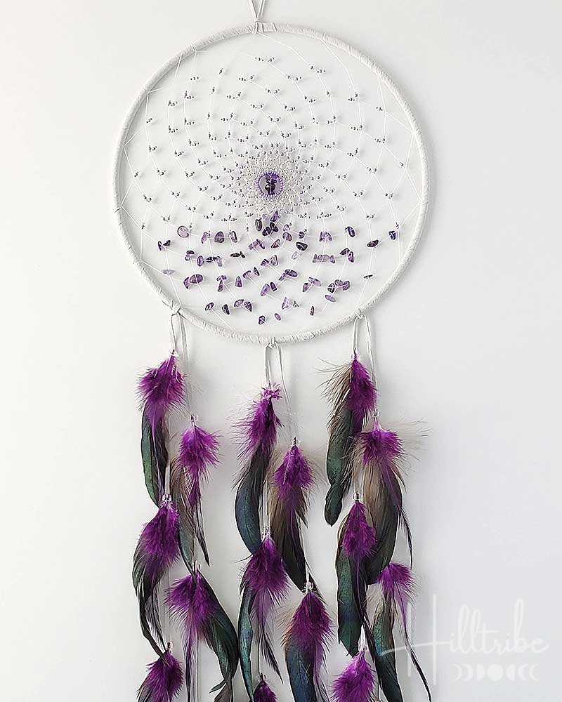 White dreamcatcher with purple feathers on a white background
