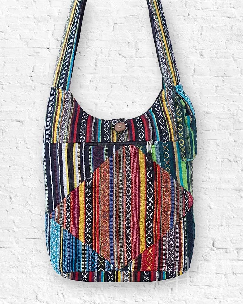 Colorful patterned shoulder bag on a white brick wall background