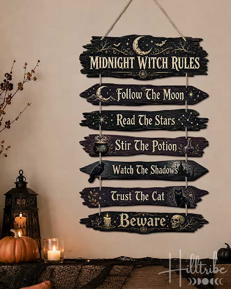 A rustic multi-tiered wooden sign with the text 'Midnight Witch Rules' and seven spooky phrases, hanging on a beige wall above a decorated mantel with pumpkins, candles, and black lace.