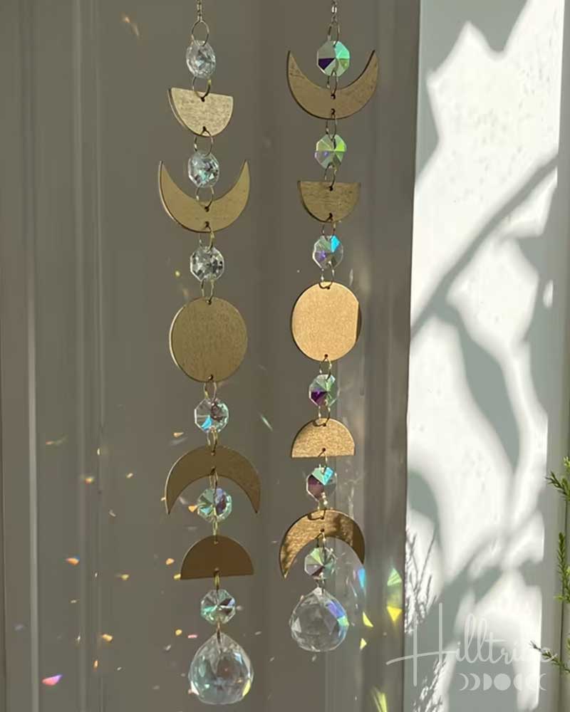 Decorative hanging with gold crescent moons and crystal beads against a light background