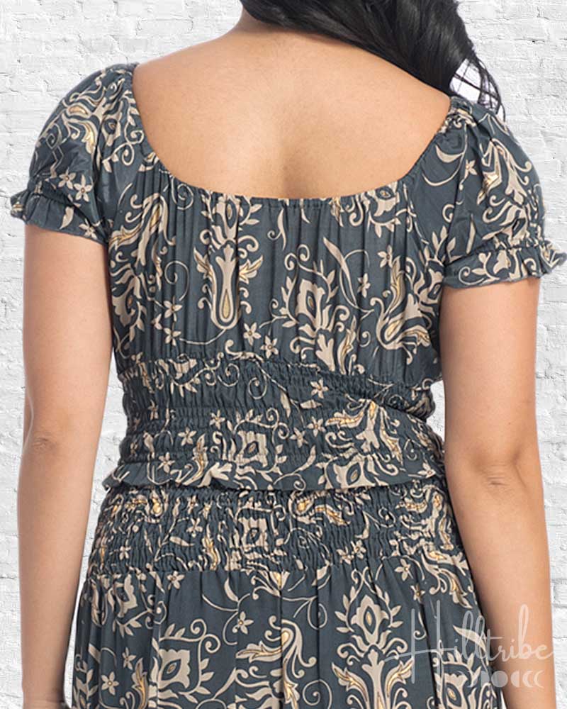 Woman wearing a patterned dress with a white brick wall background