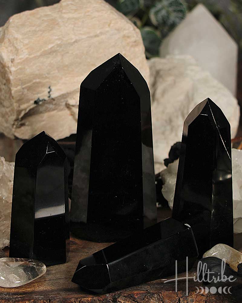 Black Obsidian Gemstone Polished Point crystals on a wooden surface with blurred natural background