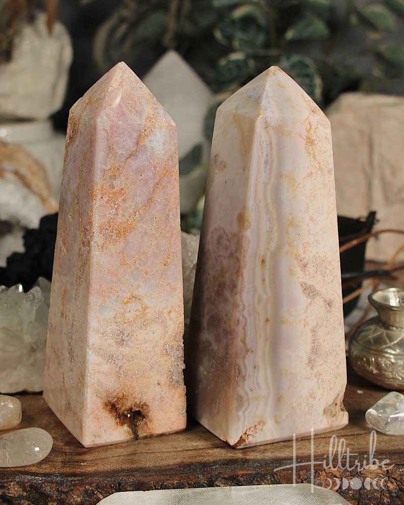 Rose Pink Amethyst stone obelisks on a wooden surface with a blurred background
