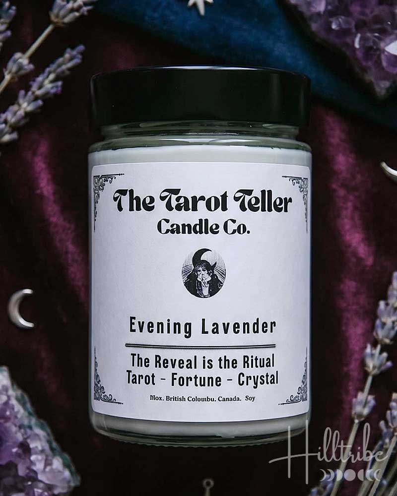 A candle jar labelled 'The Tarot Teller Candle Co.' and 'Evening Lavender' is centred against a dark purple velvet background with lavender sprigs, crystal clusters, stars, and crescent moons.