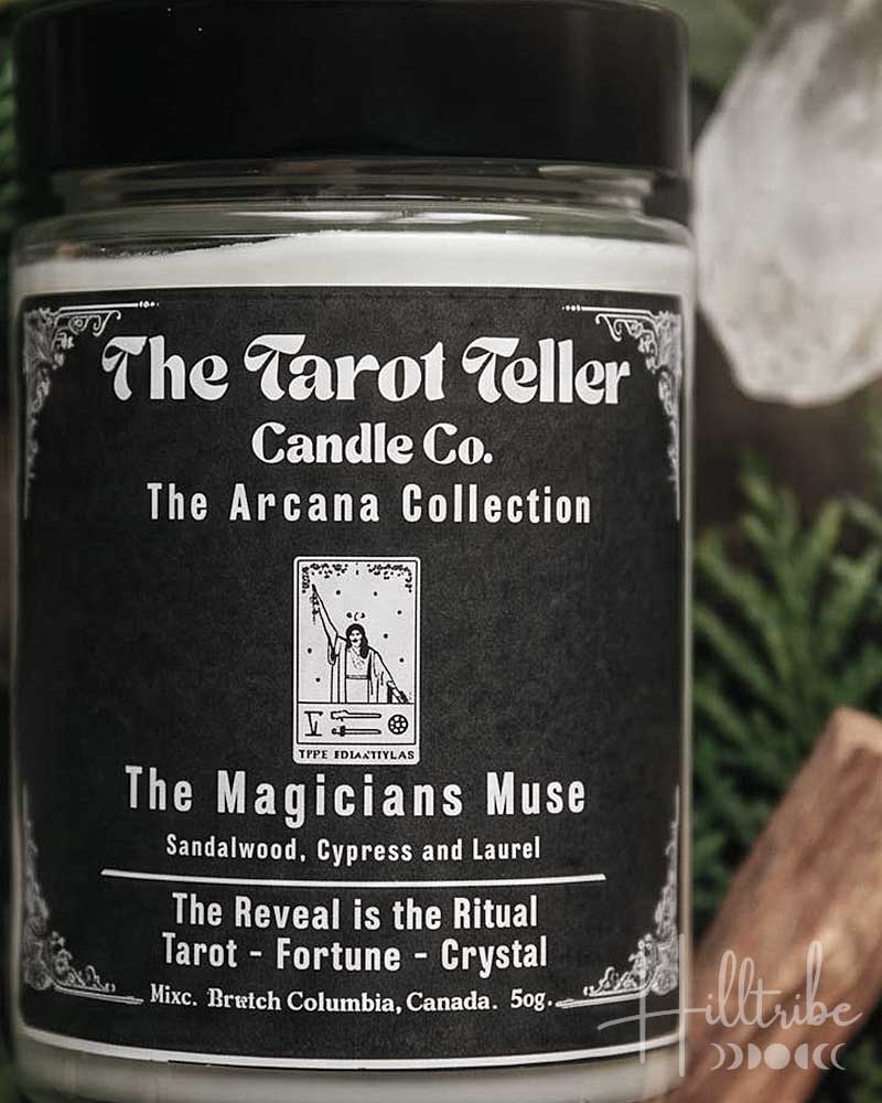 A jar candle labelled 'The Magicians Muse' by The Tarot Follower Candle Co. is centred among green leaves, cinnamon sticks, and clear crystals, with the text 'The Magician's Muse' at the top and 'A Ritual of Sandalwood, Cypress & Laurel' at the bottom.