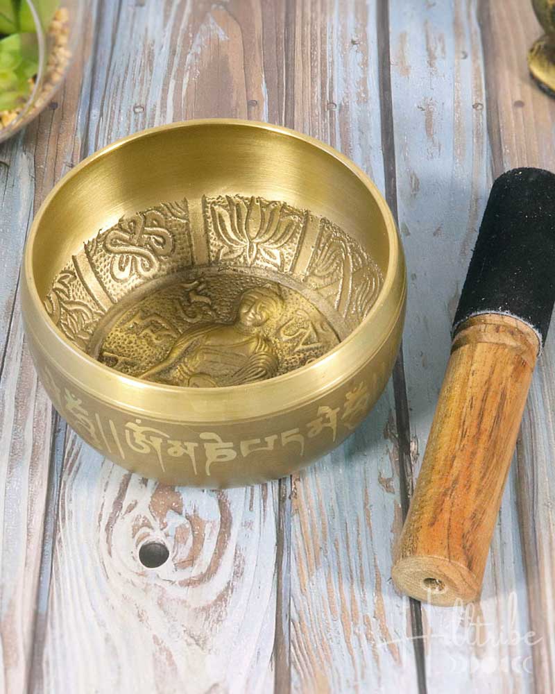Brass singing bowl with engraved design on a wooden surface