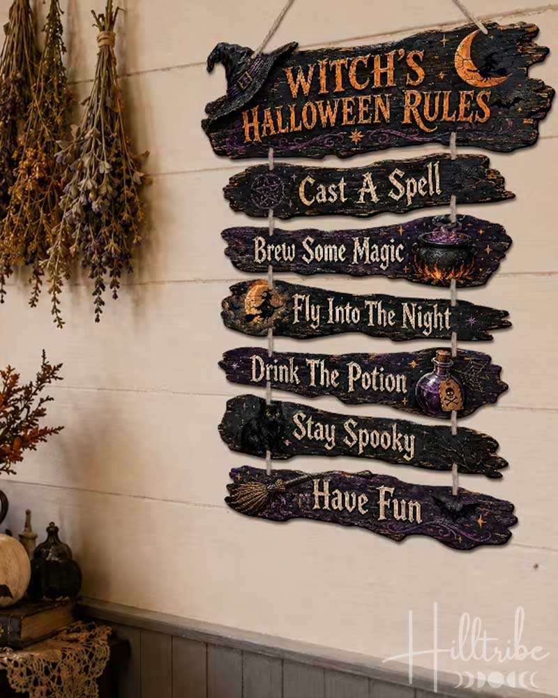 A rustic wooden hanging sign with the text 'Witch's Halloween Rules' and seven listed phrases, displayed on a cream wall in a styled room with pumpkins, dried flowers, and shelves.