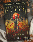 Amber Moon Tarot card set packaging with a woman in a field of flowers and red moon.