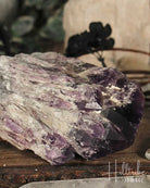 Amethyst crystal cluster on a wooden surface with blurred background