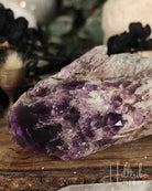 Close-up of a purple crystal on a wooden surface with blurred background