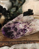 Amethyst crystal on a wooden surface with blurred background