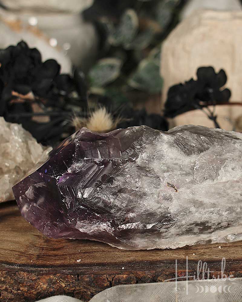 Amethyst crystal on a wooden surface with blurred background