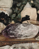 Amethyst crystal on a wooden surface with blurred background