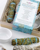 Sacred smudge kit for beginners with sage and white sage sticks on a white surface.