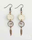 Pair of dreamcatcher earrings with circular stones and feathers on a white background