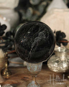 Black Tourmaline sphere on a stand with a blurred background