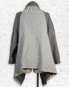 Gray coat with a unique design on a white brick wall background