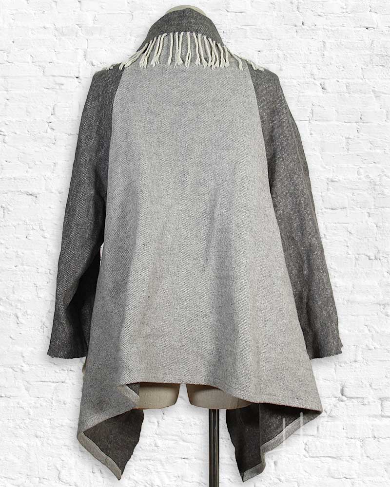 Gray coat with a unique design on a white brick wall background