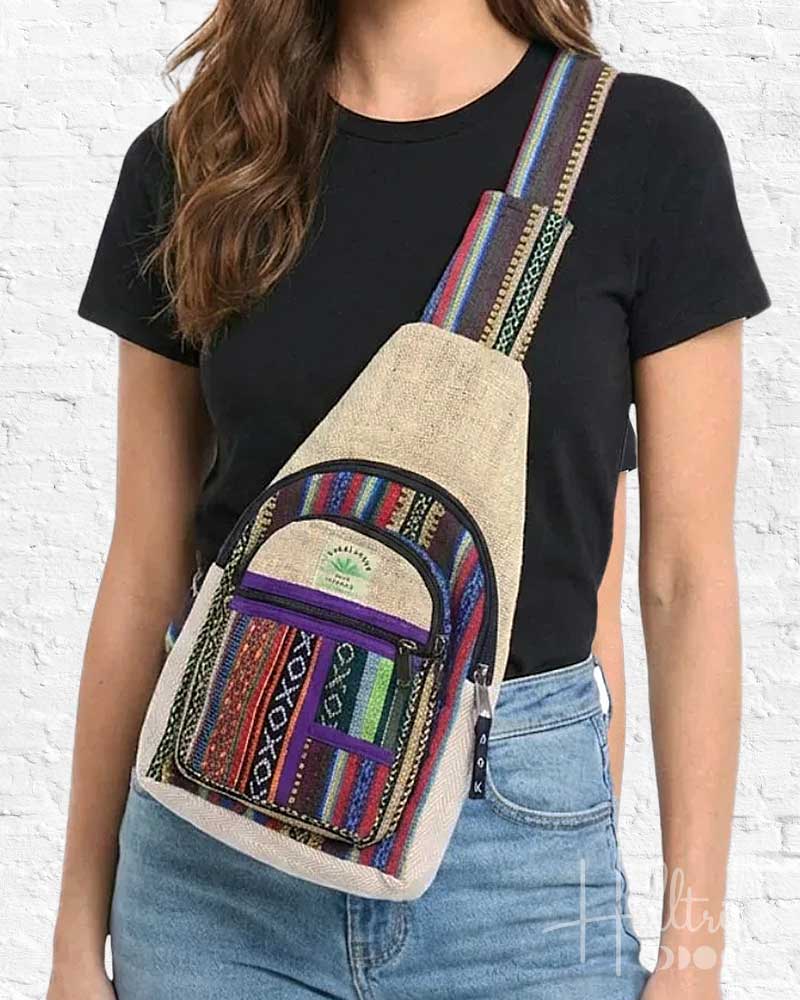 Person wearing a colorful backpack with a white brick wall background