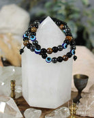 Two black beaded bracelets on a crystal with 'Hilltribe' branding.
