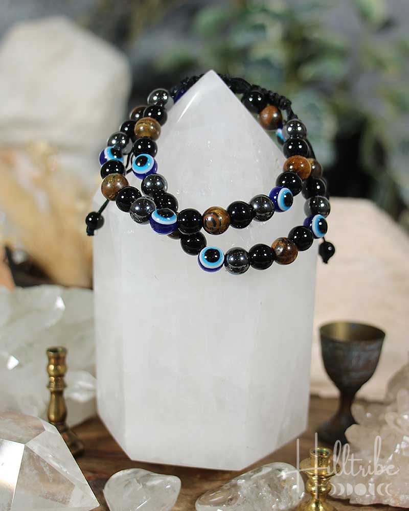 Two black beaded bracelets on a crystal with 'Hilltribe' branding.