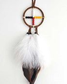 Dreamcatcher with feathers and beads on a white background