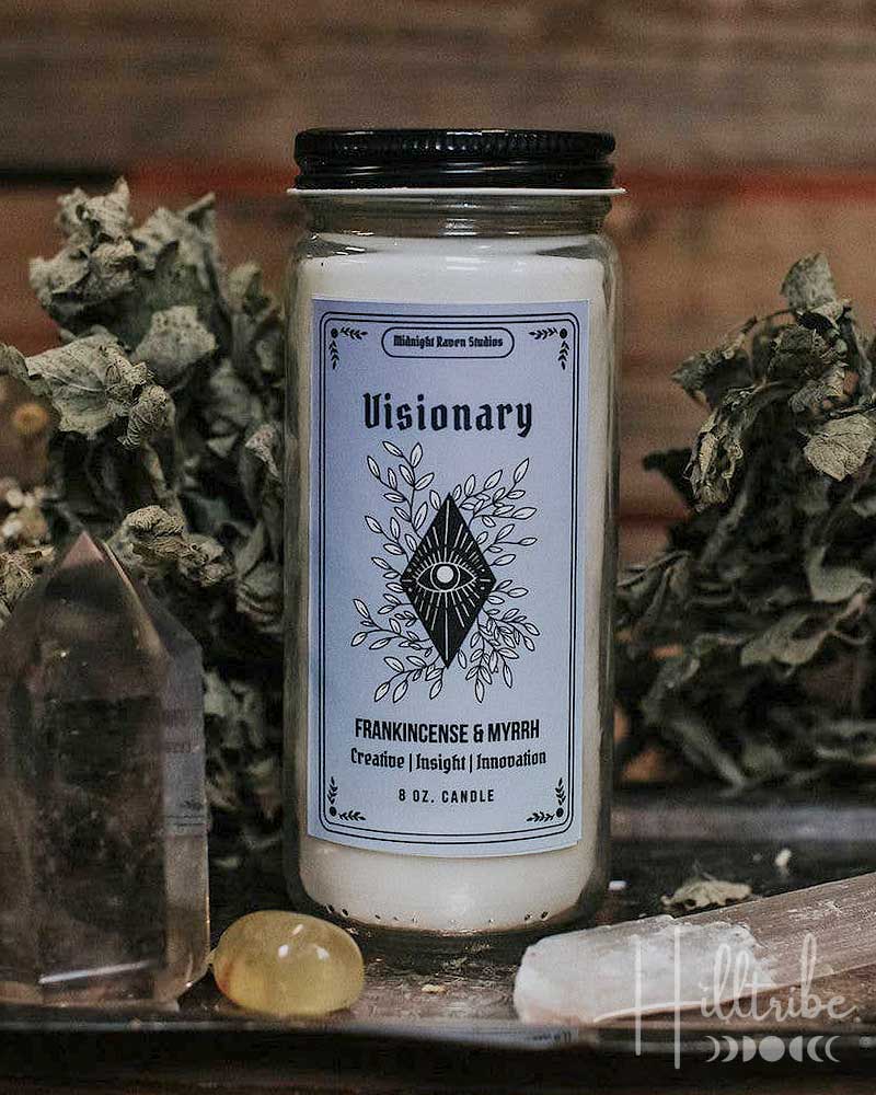 Candle labeled 'Visionary' with decorative elements on a rustic background