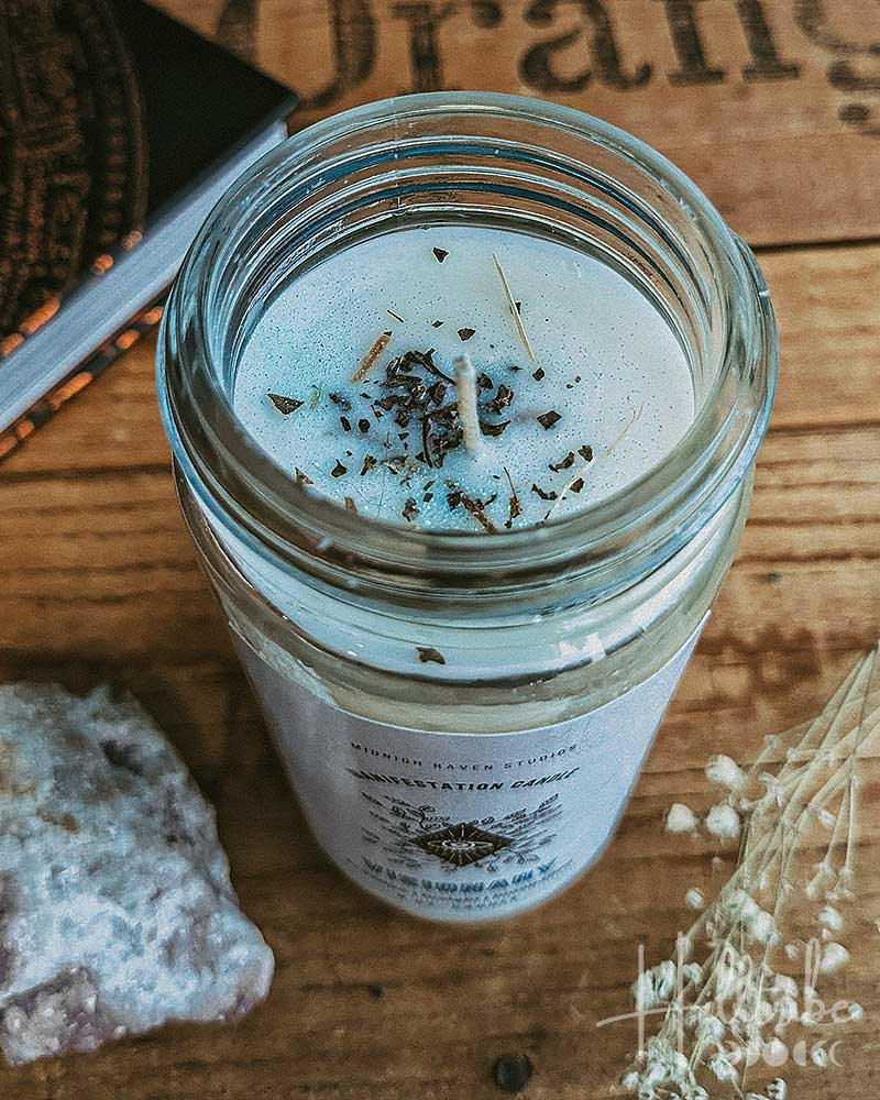 Candle in a glass jar with decorative elements on a wooden surface