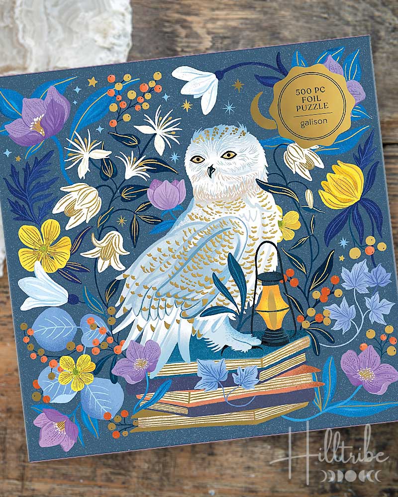 A 500-piece foil puzzle box by Galton titled 'Celestial Owl'. The box features a detailed illustration of an owl perched on books surrounded by flowers and a lantern against a dark blue starry background.