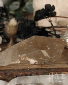 Smoky Citrine crystal on a wooden surface with blurred background