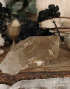 Smoky Citrine crystal on a wooden surface with blurred background