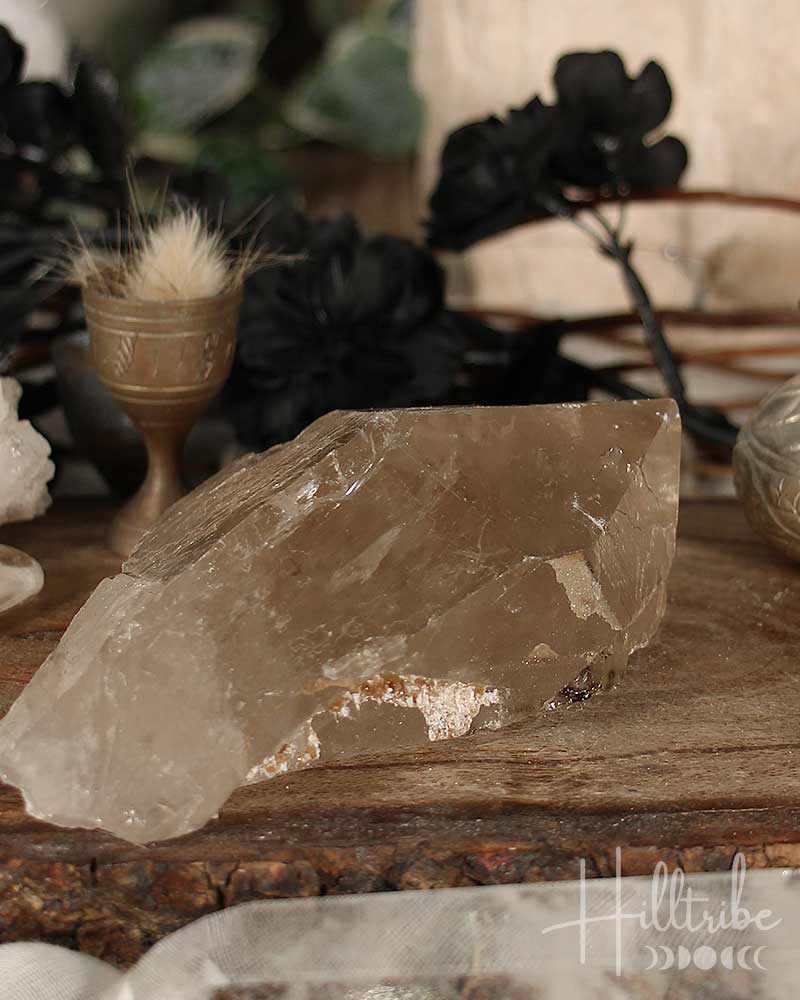 Smoky Citrine crystal on a wooden surface with blurred background