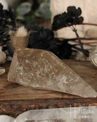 Smoky Citrine crystal on a wooden surface with blurred background