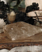 Smoky Citrine crystal on a wooden surface with blurred background