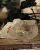 Natural Smoky Citrine crystal on a wooden surface with a blurred natural background