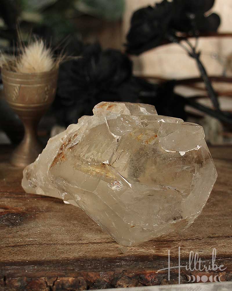 Natural Smoky Citrine crystal on a wooden surface with a blurred natural background