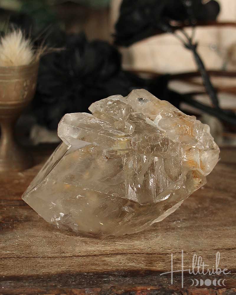 Natural Smoky Citrine crystal on a wooden surface with a blurred natural background