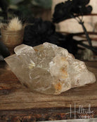 Natural Smoky Citrine crystal on a wooden surface with a blurred natural background