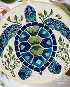 Mosaic turtle art piece with blue and green colors on a white background