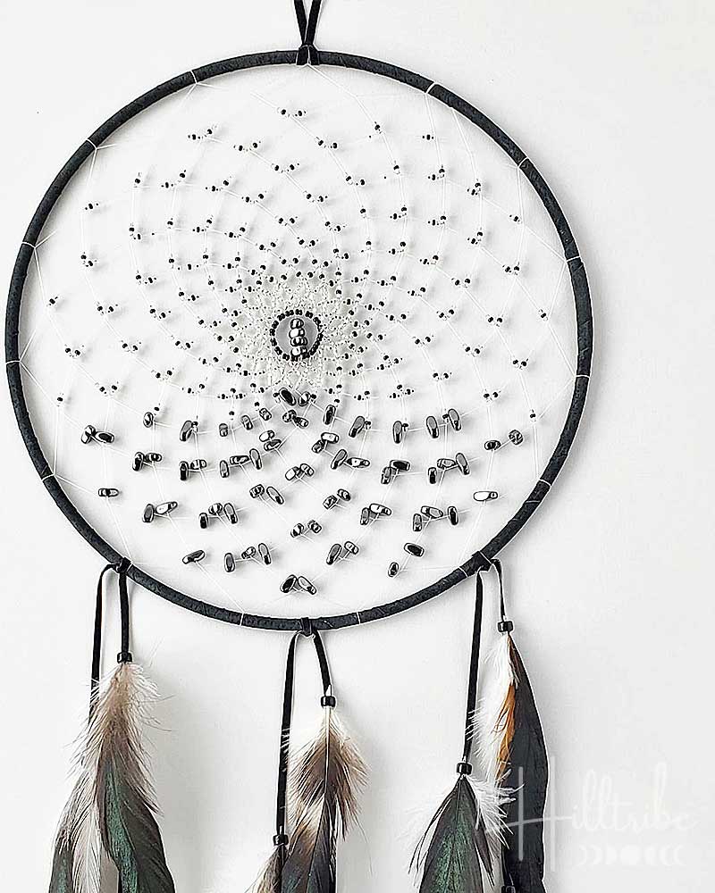 Dreamcatcher with feathers on a white background