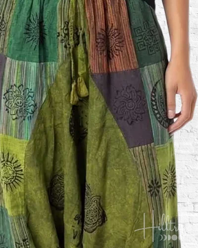 Green patchwork dress with intricate patterns on a white background