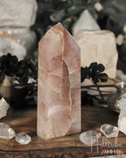 Fire Quartz Polished crystal Point on a wooden surface with blurred natural background