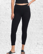 Person wearing black leggings against a white brick wall