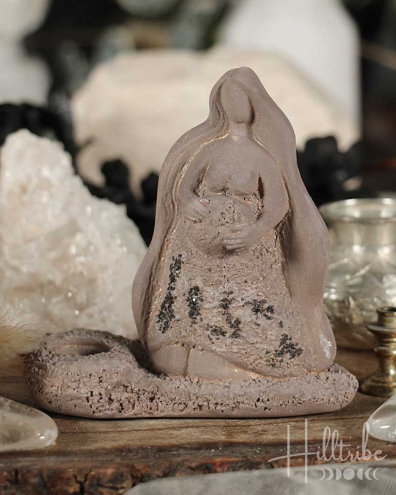 Decorative figurine of a woman in a meditative pose on a wooden surface with blurred background
