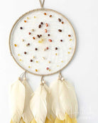 Dreamcatcher with white feathers and bead design on a white background
